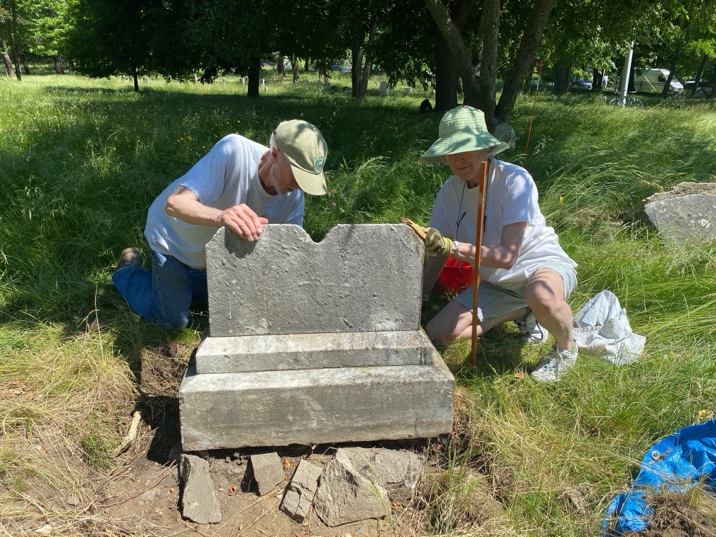 Volunteers Landis and Dominique Gabel clean a double gravestone
